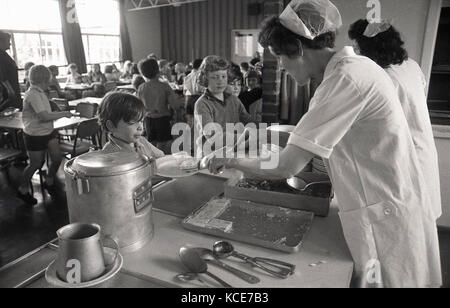 1970s, historical, school dinner ladies serving food to children at lunchtime, Langbourne Primary School, Dulwich, London, SE21, England, UK. Stock Photo