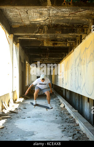KUPARI, CROATIA - JULY 18, 2017 : A young man skateboarding in an hotel in abandoned Yugoslavian military resort in Kupari, Croatia. Stock Photo