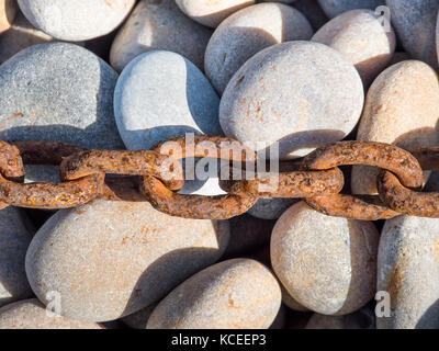rusty anchor chain shingle stones Stock Photo