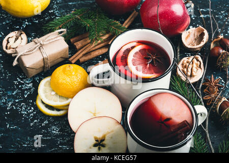 Mulled wine with apple and lemon  slices in white rural mugs  on rustic table Stock Photo