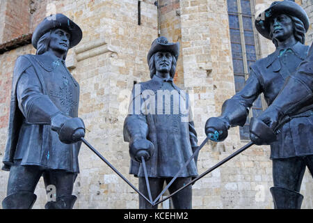 CONDOM, FRANCE, June 24, 2015 : The statue of d'Artagnan and three musketeers, from the Georgian sculptor Zurab Tsereteli, lies at the foot of the Cat Stock Photo