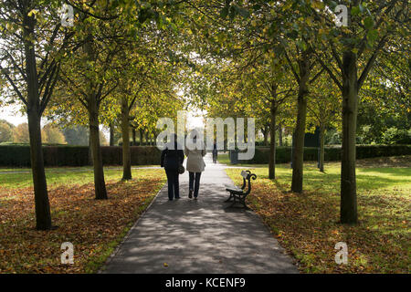 Two ladies walking through a tree lined path in Rowntree Park, York. Stock Photo