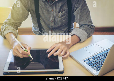 Close-up of business man using tablet and computer to working financial data. Stock Photo
