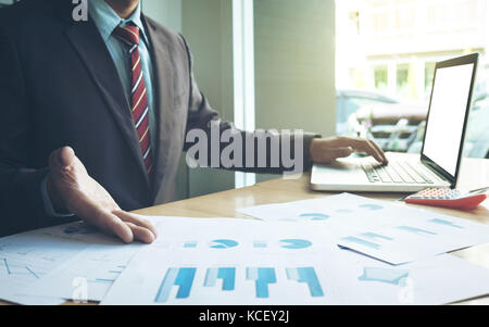 Business concept, Young business man's hands working with laptop and document graph on wood table. Stock Photo