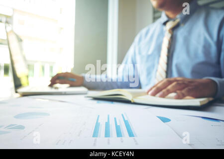 Business concept, Young business man's hands working with laptop and document graph on wood table. Stock Photo