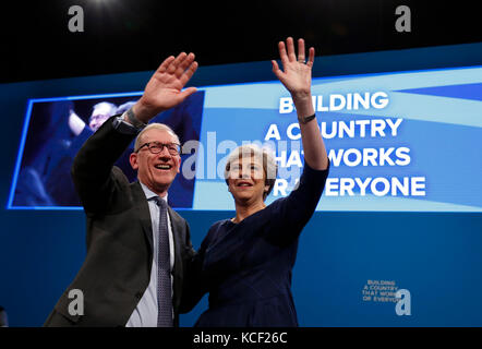 Manchester. 4th Oct, 2017. Britain's Prime Minister Theresa May waves to the attendees with her husband Philip after delivering her keynote speech on the last day of the Conservative Party Annual Conference in Manchester, Britain on Oct. 4, 2017. Credit: Han Yan/Xinhua/Alamy Live News Stock Photo
