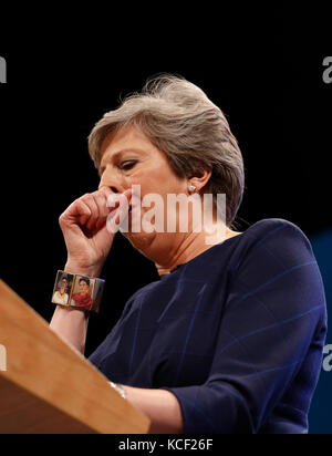 Manchester. 4th Oct, 2017. Britain's Prime Minister Theresa May coughs during her keynote speech to delegates and party members on the last day of the Conservative Party Annual Conference in Manchester, Britain on Oct. 4, 2017. Credit: Han Yan/Xinhua/Alamy Live News Stock Photo