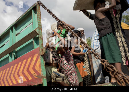 Cox's Bazar, Bangladesh. 4th Oct, 2017. Newly arrived Rohingya refugees take water and get down from a truck in front of a camp who comes from Myanmar Rakhain state, at Ukhiya, Cox's Bazar. According to the UNHCR more than 500,000 Rohingya refugees have fled Myanmar from violence over the last month, most trying to cross the border and reach Bangladesh. Credit: ZUMA Press, Inc./Alamy Live News Stock Photo
