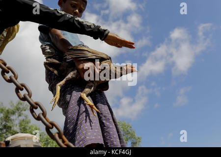 Cox's Bazar, Bangladesh. 4th Oct, 2017. Newly arrived Rohingya refugees with hen get down from a truck in front of a camp who comes from Myanmar Rakhain state, at Ukhiya, Cox's Bazar. According to the UNHCR more than 500,000 Rohingya refugees have fled Myanmar from violence over the last month, most trying to cross the border and reach Bangladesh. Credit: ZUMA Press, Inc./Alamy Live News Stock Photo