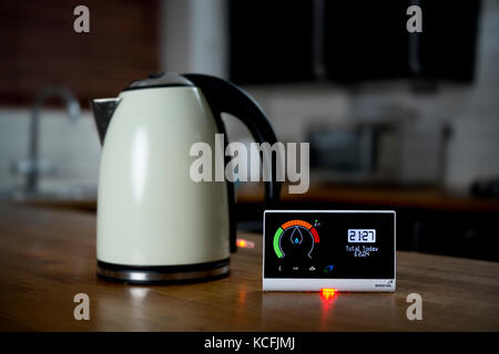 A domestic use British Gas energy smart meter displaying the cost of gas electricity usage in a UK home, sat by the side of an electric kettle. Stock Photo