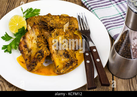 Spicy meat ribs in mustard sauce on wooden table Stock Photo