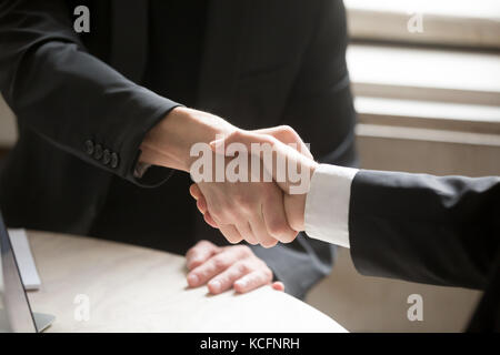 Close up of two business people shaking hands. Executive corporate representatives greeting each other, giving handshake to close good deal, welcoming Stock Photo