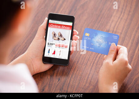 Close-up Of Businessperson With Mobile Phone Showing Online Shopping Application And Credit Card Stock Photo