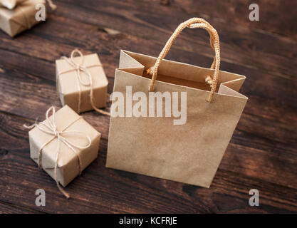 Mockup kraft Carton gift Box and Handle Package on wooden background for Design, Website, Background Stock Photo