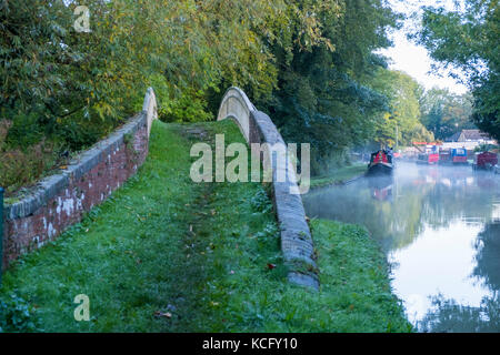 An early morning autumn mist begins rising on the Oxford Canal by Bridge 45 near Newbold on Avon.