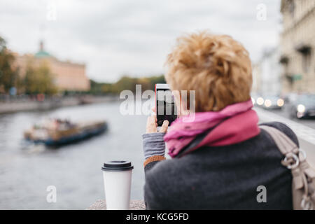 Woman taking shots from waterfront Stock Photo