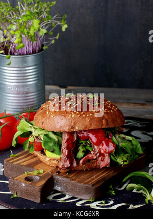 Fresh meat Burger with greens on wooden Board Stock Photo