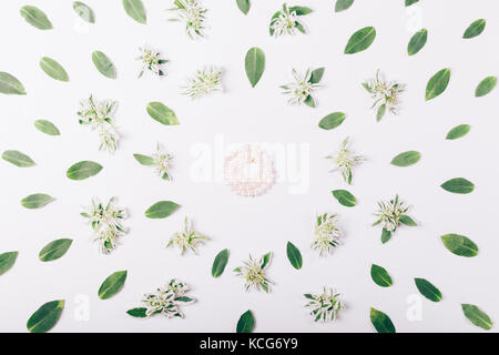Pearl bracelet on white table among the green leaves, top view Stock Photo