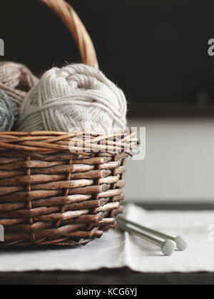 The wool yarn in wooden brown basket with needles Stock Photo