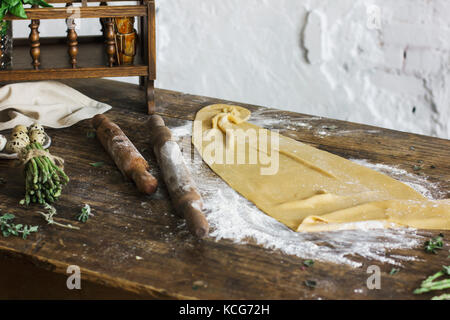 Ingredients for making homemade pasta, rolling pin, quail eggs, asparagus on wooden table Stock Photo