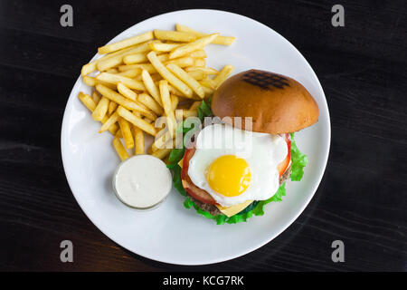 Meat Burger with egg, sauce and fries Stock Photo