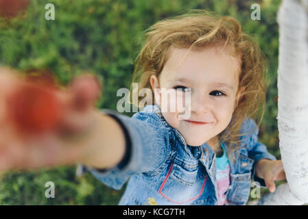 Happy little girl picking cherry in garden Stock Photo