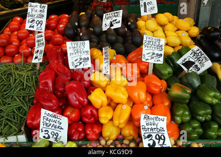 market stall with red & yellow peppers, tomatoes, avocado, green bean, lemons & yakima, Seattle, USA Stock Photo