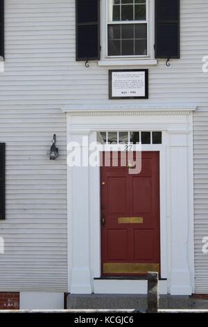 A beautiful red door on the home of a colonial americana home in the new england north atlantic region of plymouth massachusetts Stock Photo