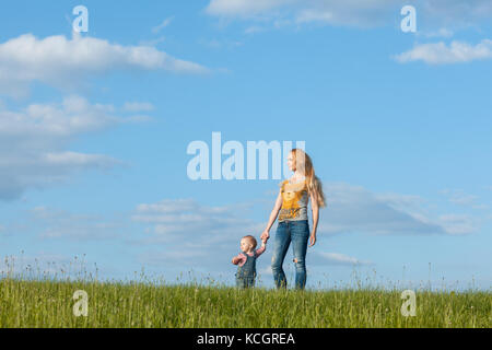 Young mother and daughter walking along the skyline Stock Photo