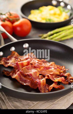 Frying pan with cooked bacon rashers on white background Stock Photo - Alamy