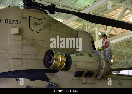 U.S. Army Specialist Pamela Howe, an aircraft mechanic from the Ohio National Guard’s 3-238th General Aviation Support Battalion, performs routine maintenance on two Boeing CH-47F Chinook aircraft at McEntire Joint National Guard Base, S.C., before continuing on to Naval Air Station Cecil Field in Jacksonville, Florida as part of a response to Hurricane Irma, Sept. 12, 2017.  McEntire JNGB served as a transition point for the unit to refuel before heading on to Florida. Both aircraft recently responded to the damage and flooding in Texas caused by Hurricane Harvey by moving supplies and person Stock Photo