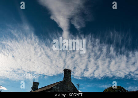 UK Weather, dense cirrus cloud formation with an unusual disturbance over a rooftop in North Yorkshire with copy space Stock Photo