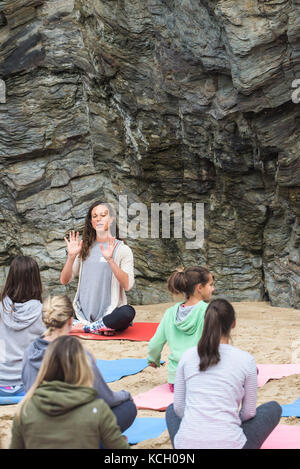 A womens' group practising yoga on a beach - Surf Betty’s Festival - a festival held in Newquay empowering women through fitness and surfing. Stock Photo