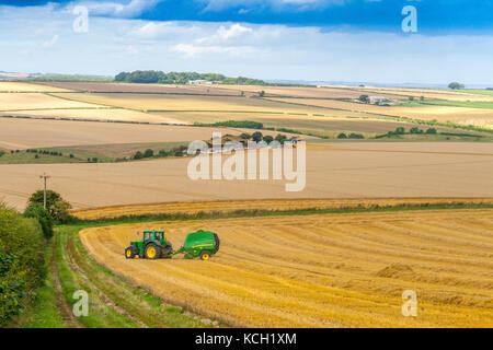 John Deere Tractor and round baler on Yorkshire Wolds Stock Photo