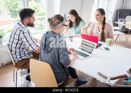 Dedicated young woman editing a document in a modern office spac Stock Photo