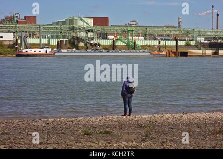 Woman standing on bank of river Rhine Stock Photo