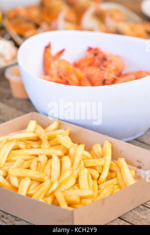 Classic Australian seafood lunch of french fries, shrimp, crab and more on outdoor table Stock Photo
