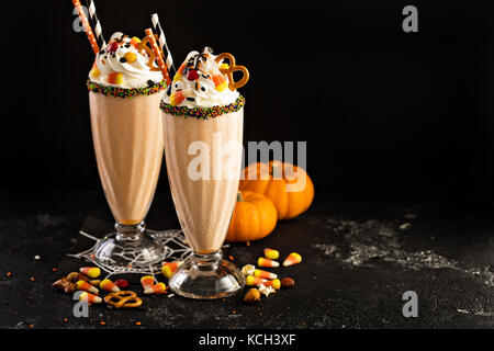 Halloween pumpkin milkshake decorated with candy Stock Photo