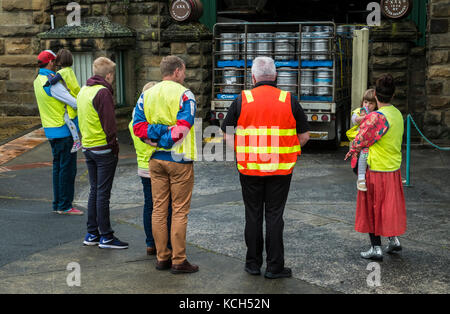 A family in high visibility yellow begins a tour of the Cascade Brewery in South Hobart, Tasmania. The guide is in orange hi vis vest. Stock Photo