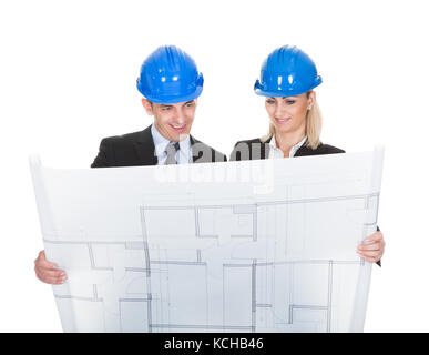 Male And Female Architects Looking At Blueprint Over White Background Stock Photo