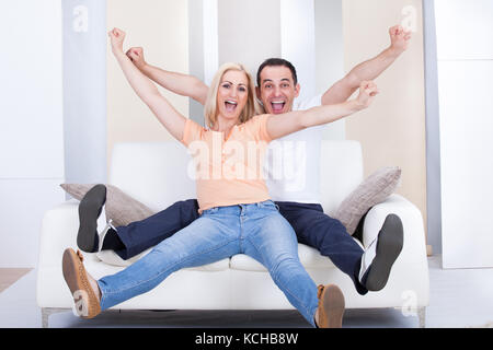 Portrait of happy couple raising hand in excitement Stock Photo