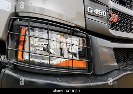 ORIPAA, FINLAND - SEPTEMBER 30, 2017: Detail of headlamp protection and grille of the new Scania XT G450 heavy duty truck in rain. Stock Photo