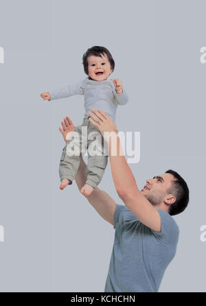 Joyful father giving piggyback ride to his son against a white b Stock Photo