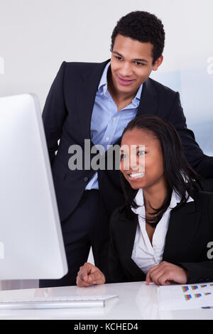 Portrait Of Happy Business People Sitting At The Desk Stock Photo
