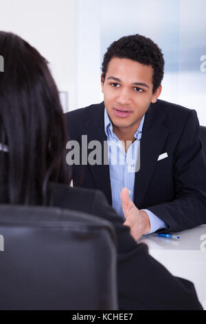 Portrait Of Businessman Discussing With His Co-worker In Office Stock Photo