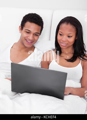 Portrait Of Young African Couple Looking At The Laptop Stock Photo
