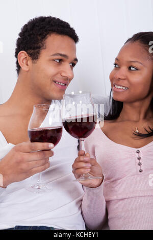 Portrait Of Young African Couple Toasting Red Wine Stock Photo