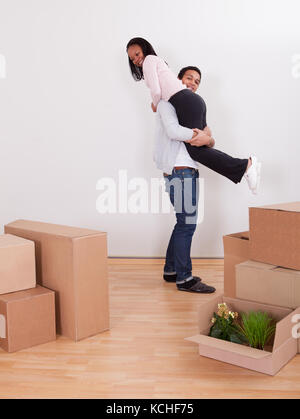 Portrait Of Man Carrying Woman On Shoulder In House Stock Photo