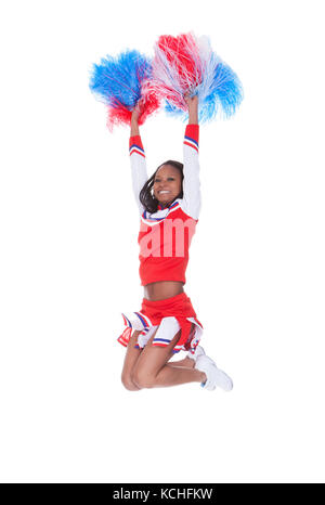 Smiling beautiful cheerleader with pompoms. Isolated on white Stock Photo