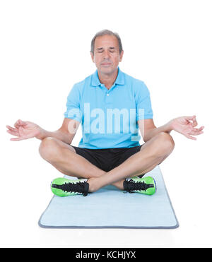 Mature Man Practicing Yoga In The Lotus Position Over White Background Stock Photo